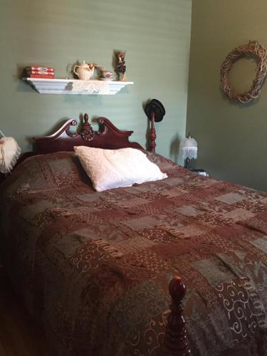 a bedroom with a bed with a red comforter at Le Gîte De La Sagouine in Bouctouche