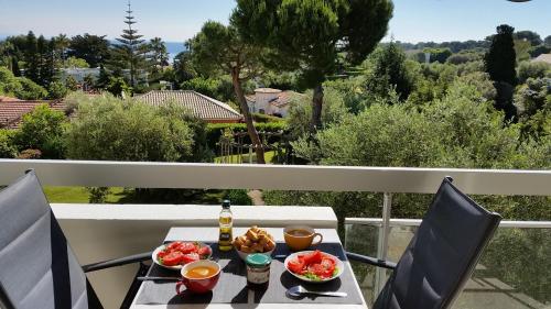 une table avec de la nourriture et des boissons sur un balcon dans l'établissement Green Cap d'Antibes, à Antibes
