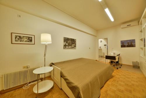 1 dormitorio con cama, mesa y escritorio en Architect Designer's Apartment in Kolonaki, en Atenas