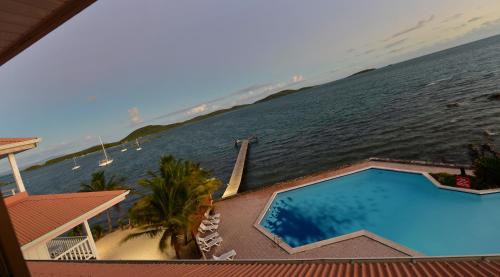 a view of the ocean from a house with a swimming pool at Le Stanley Hôtel in Noumea