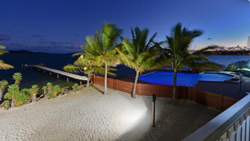 a balcony with palm trees and a swimming pool at Le Stanley Hôtel in Noumea