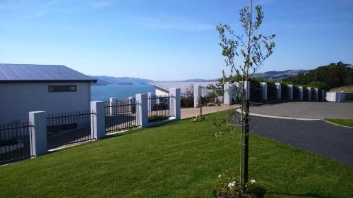 a small tree in a yard with a fence at Restview in Dunedin
