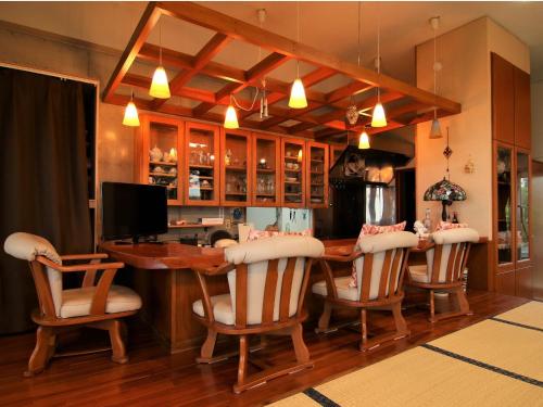- une salle à manger avec une table et des chaises en bois dans l'établissement Minshuku Tantawan -SEVEN Hotels and Resorts-, à Motobu