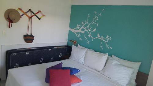 um quarto com uma cama com almofadas brancas em Flat Ancorar 2201 em Porto de Galinhas