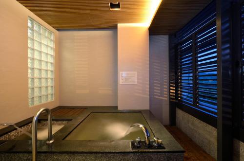 a bathroom with a sink and a shower stall at The Sun Hot Spring & Resort in Taichung