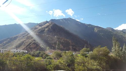 a mountain with a town in front of it at Tambo de Ollantay Hotel in Ollantaytambo