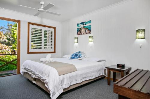 ein weißes Schlafzimmer mit einem Bett und einem Fenster in der Unterkunft Lorhiti Apartments in Lord Howe