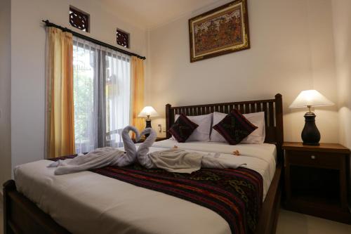a bedroom with a bed with two people laying on it at The Jero Ubud in Ubud
