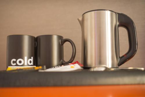two silver coffee mugs sitting on a table at SUN & MOON, Urban Hotel in Phnom Penh