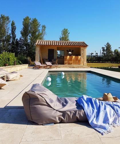 une piscine avec une maison en arrière-plan dans l'établissement Fontaine de Cérier, à Castillon-du-Gard