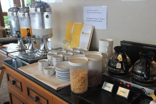 a counter with cups and plates and a coffee machine at Must Sea Hotel - SHA Hotel in Kata Beach
