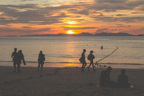 a group of people on the beach at sunset at Railay Bay Resort & Spa in Railay Beach