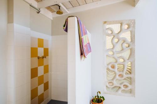 a bathroom with a shower and a towel on the wall at The Blue Beach House in Quinns Rocks