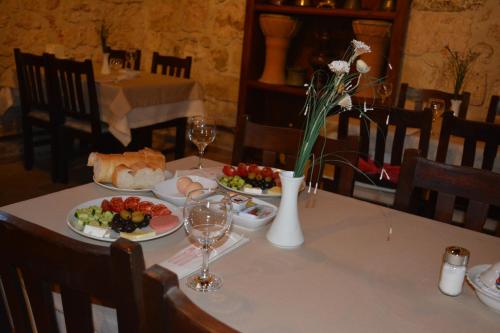 a table with plates of food and wine glasses at Osmanli Marco Pasha Hotel in Tarsus