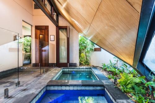 an external view of a swimming pool in a house at Niramaya Villas and Spa in Port Douglas