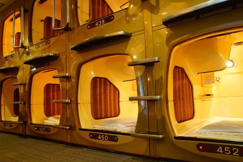 a row of four train cars parked in a room at Capsule Inn Kinshicho in Tokyo