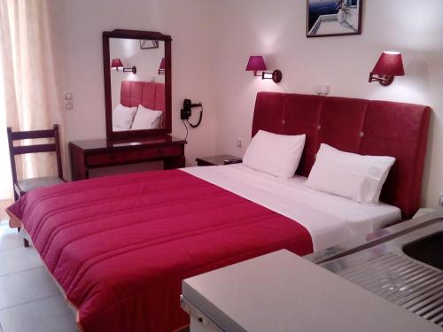 a bedroom with a large bed with a red blanket at Hotel Romantica in Loutra Edipsou