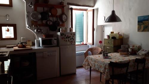 eine Küche mit einem Tisch und eine kleine Küche mit einem Tisch und einem Tisch in der Unterkunft La Casa Di Dina in Castelmuzio