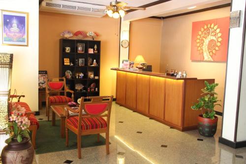a waiting room with chairs and a table and a counter at B.S. Court Hotel Sathorn in Bangkok
