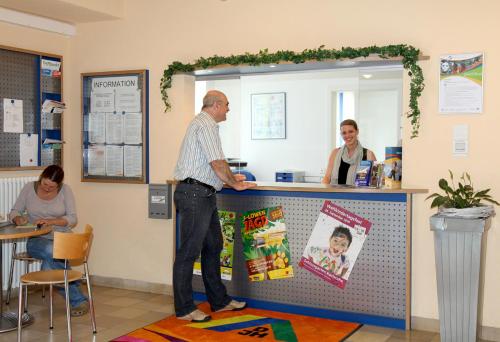 a man standing at a counter in a store at Jugendherberge Karlsruhe in Karlsruhe