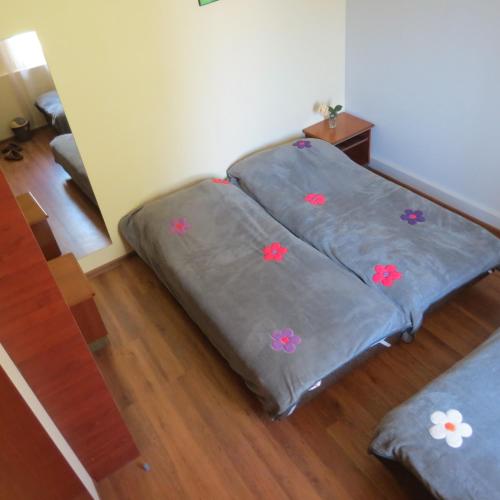 two beds in a room with flowers on them at Tvishi Guest House in Tsʼageri