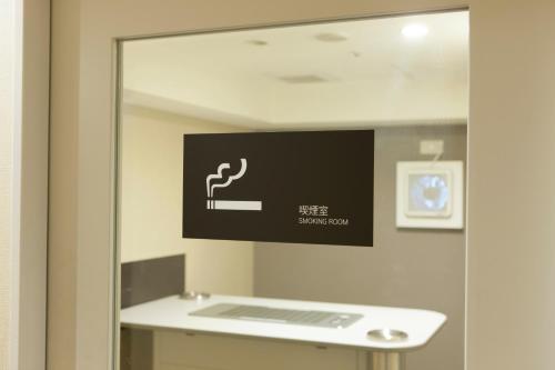 a mirror in a bathroom with a sign on the wall at Hotel Sardonyx Tokyo in Tokyo