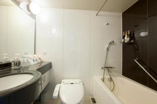 a bathroom with a toilet and a sink and a tub at Hotel Sardonyx Tokyo in Tokyo