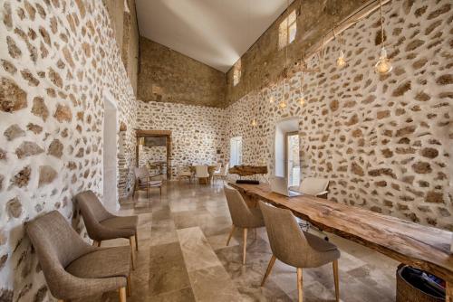 a stone walled room with a wooden table and chairs at Es Lligats Agroturismo - Adults Only in Sant Llorenç des Cardassar