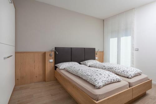 una camera con un letto con due cuscini sopra di Appartamento Mirabell ad Andalo
