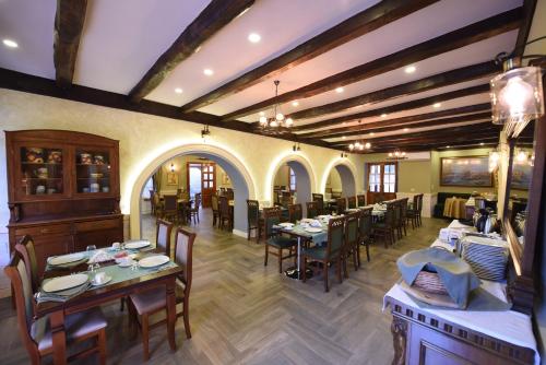 a restaurant with tables and chairs in a room at Rose Garden Hotel in Shkodër