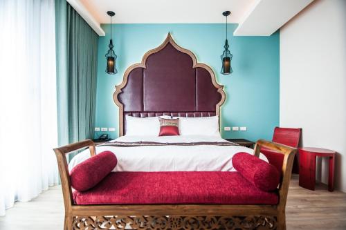 a bedroom with a large bed with a red seat at Dreamer Boutique Hotel in Nanwan