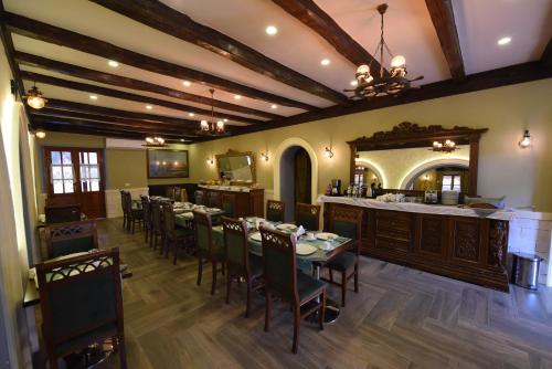 a restaurant with a table and chairs and a bar at Rose Garden Hotel in Shkodër