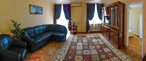 a living room with a blue leather couch and a rug at Comfort near Opera Theater in Odesa