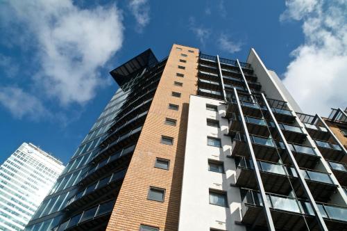 a tall building with a blue sky in the background at Fraser Place Canary Wharf in London