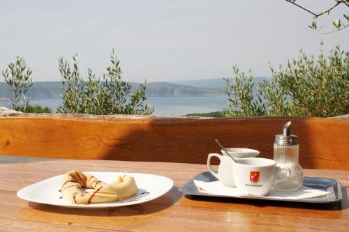 a table with two plates of food and a cup of coffee at Boutique B&B Agroturizam Sv. Juraj in Krk