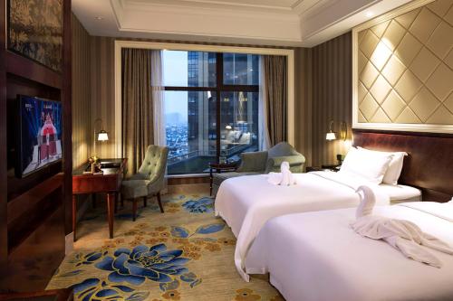 a hotel room with two beds and a large window at Chengdu Jin Yun Hotel in Chengdu