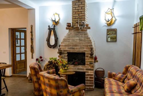 a living room with a brick fireplace and couches at Cabana Groapa Seaca in Petroşani