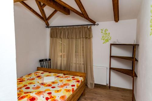 ein Schlafzimmer mit einem Bett mit einem Buch darauf in der Unterkunft Cabana Groapa Seaca in Petroşani