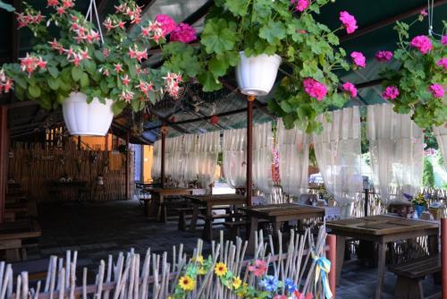 a room filled with tables and chairs with flowers at Galicky Dvir Hotel in Svityazʼ