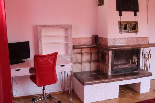 Pokój z kominkiem, biurkiem i czerwonym krzesłem w obiekcie Lila Villa Schwenningen w mieście Villingen-Schwenningen