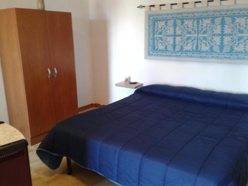 a bedroom with a blue bed and a wooden cabinet at B&b barbaricino iun F1442 in Oliena