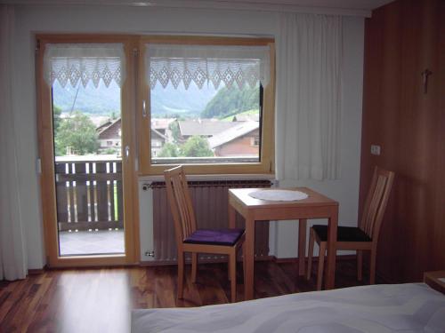 ein Schlafzimmer mit einem Tisch, Stühlen und einem Fenster in der Unterkunft Appartements am Stein in Bezau