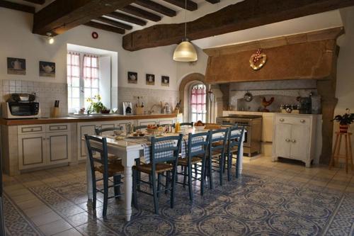 une grande cuisine avec une table et des chaises. dans l'établissement Manoir De Keringant, à Saint-Quay-Perros