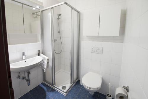 a bathroom with a shower and a toilet and a sink at myNext - Riverside Hotel Salzburg in Salzburg