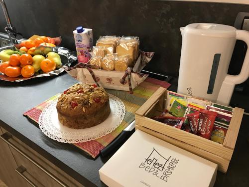 a table with a cake and a basket of fruit at Nenez B&B in Giovo
