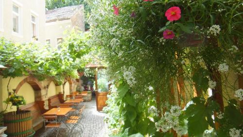 an alley with flowers and tables and chairs at Hotel Schlossberg in Meißen