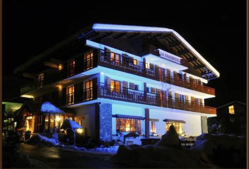 a large building with blue lights on it at night at Hôtel La Chaumière in Morzine