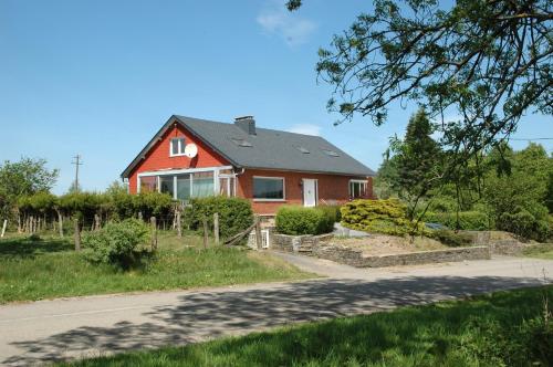 a red house on the side of a road at Villa Irene in Rienne