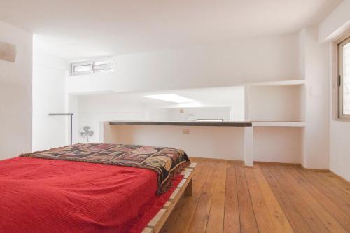 een slaapkamer met een bed met een rode deken bij Loft in Authentic Rome Hood in Rome