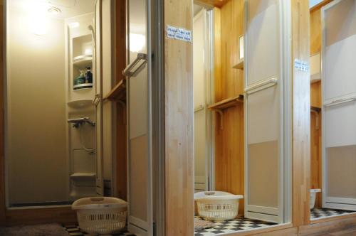 a bathroom with a mirror and two baskets on the floor at Sakura Guest House in Takayama